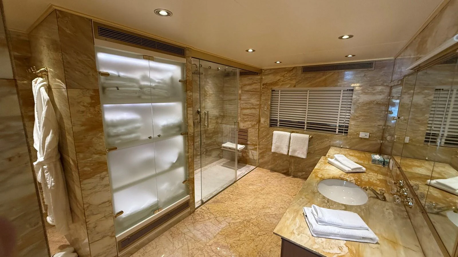 The luxurious bathroom features elegant marble surfaces and a spacious glass-enclosed shower. aboard LADY SARYA Yacht for Sale