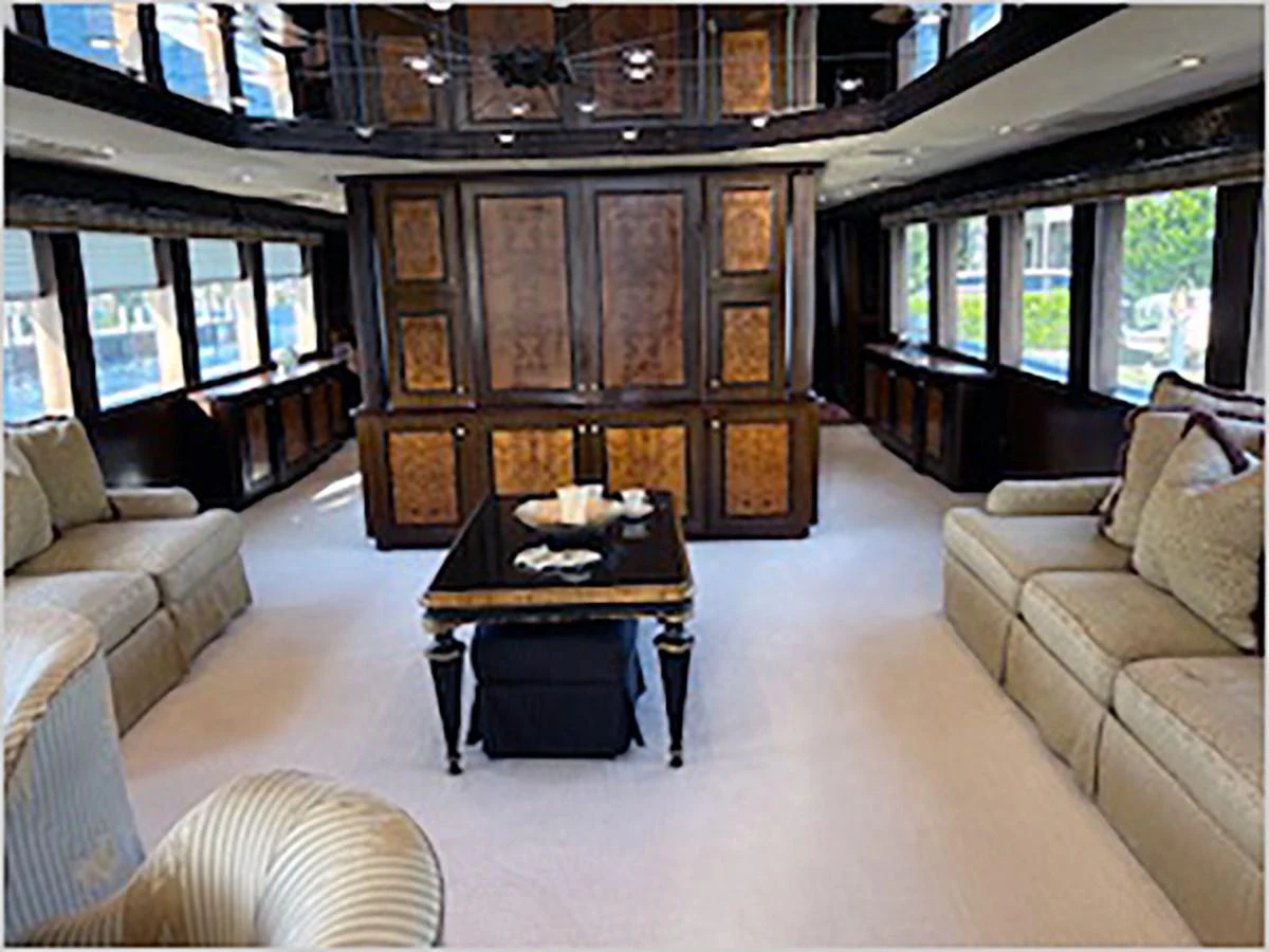 a living room with a table and couches aboard 100' HATTERAS 2001 CUSTOM YACHT Yacht for Sale