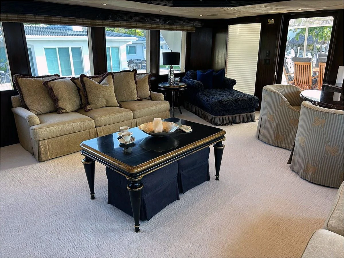 a living room with a table and chairs aboard 100' HATTERAS 2001 CUSTOM YACHT Yacht for Sale