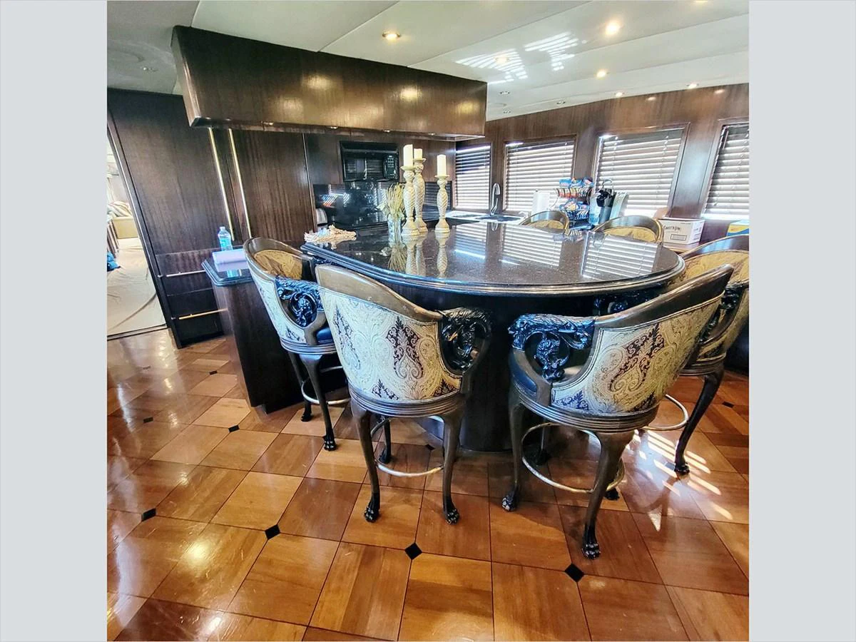 a dining table and chairs in a room aboard 100' HATTERAS 2001 CUSTOM YACHT Yacht for Sale