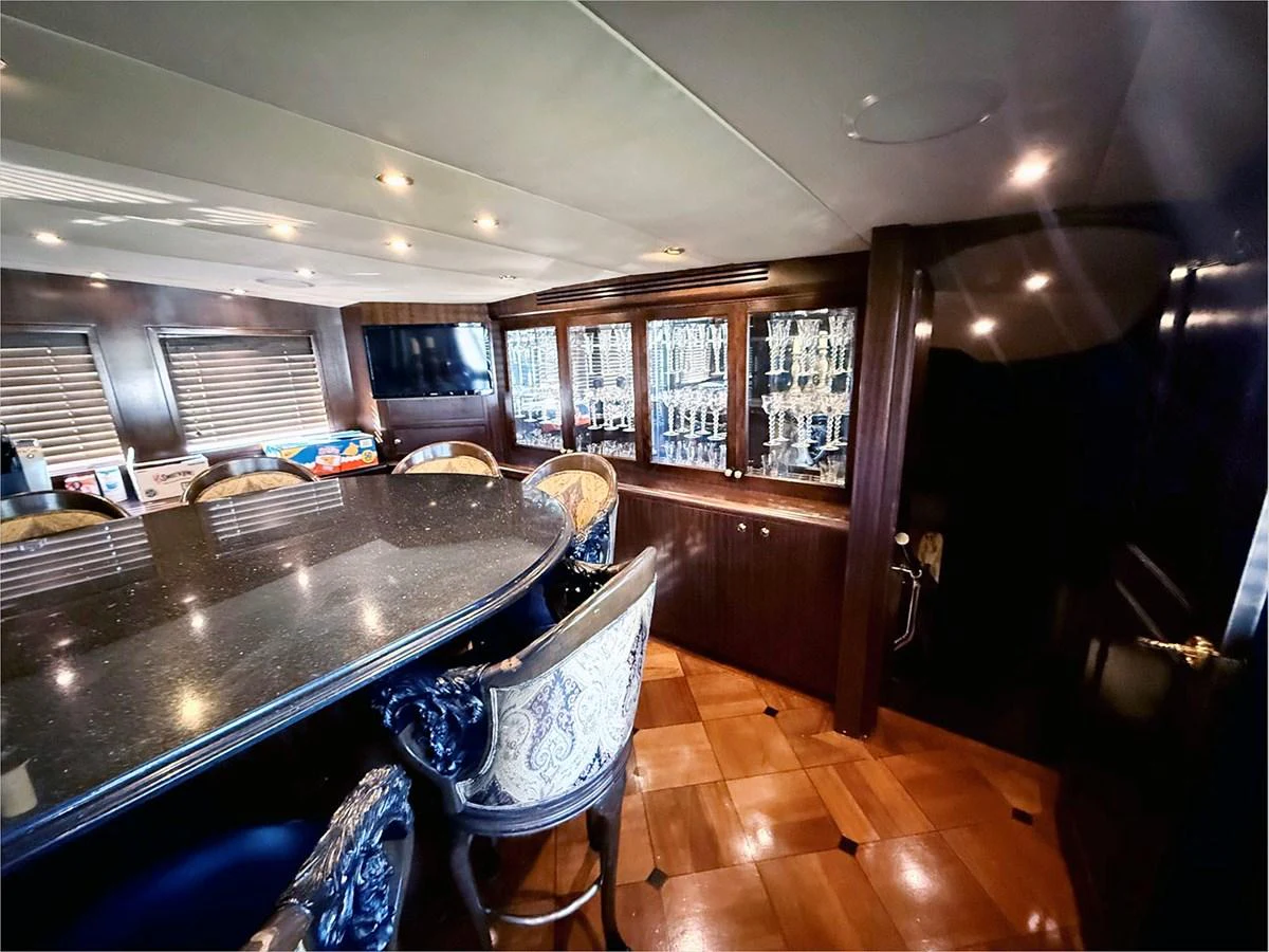 a kitchen with a bar and a bar aboard 100' HATTERAS 2001 CUSTOM YACHT Yacht for Sale