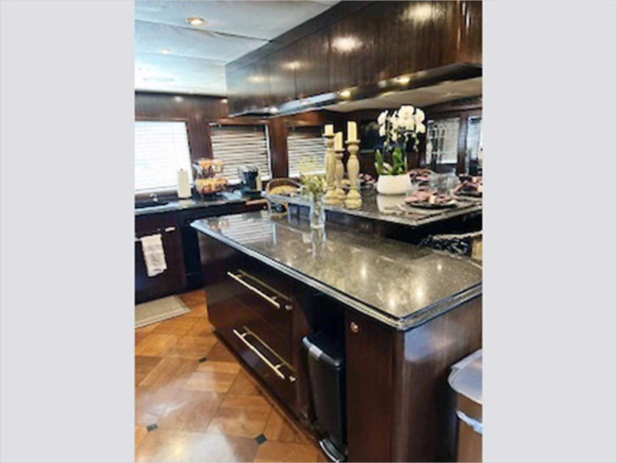 a kitchen with black counters aboard 100' HATTERAS 2001 CUSTOM YACHT Yacht for Sale