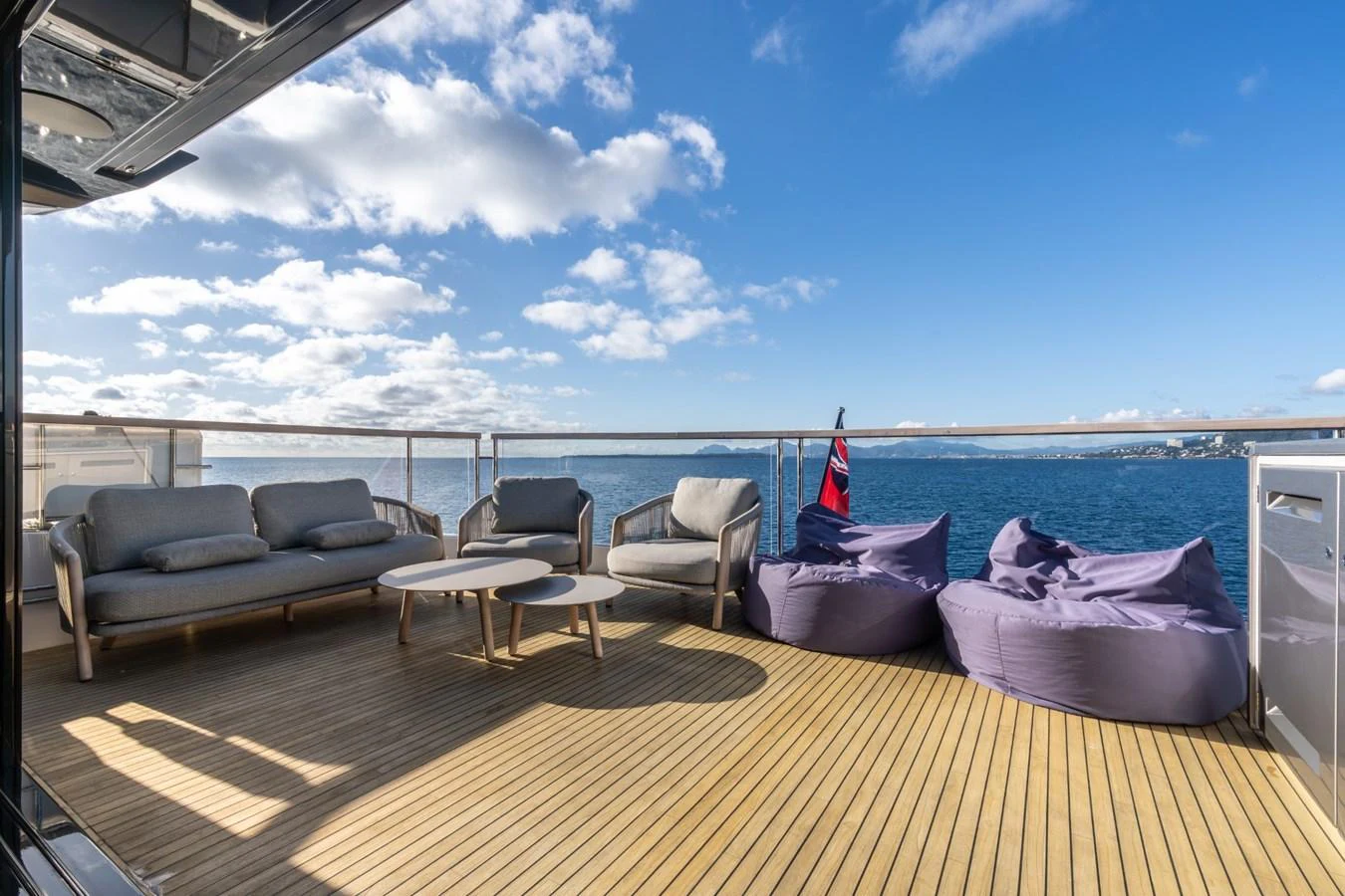 a deck with a large body of water and a beach aboard AURELIUS Yacht for Sale