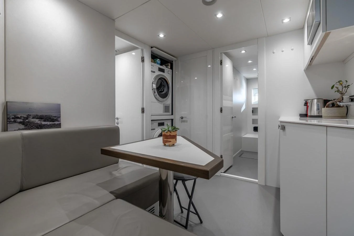 a white room with a table and a couch aboard AURELIUS Yacht for Sale
