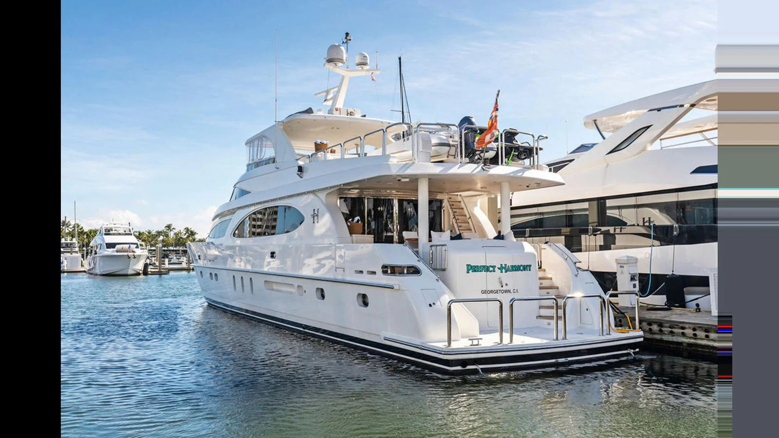 A luxurious yacht is docked at a marina, showcasing its elegant design and spacious decks. aboard PERFECT HARMONY Yacht for Sale