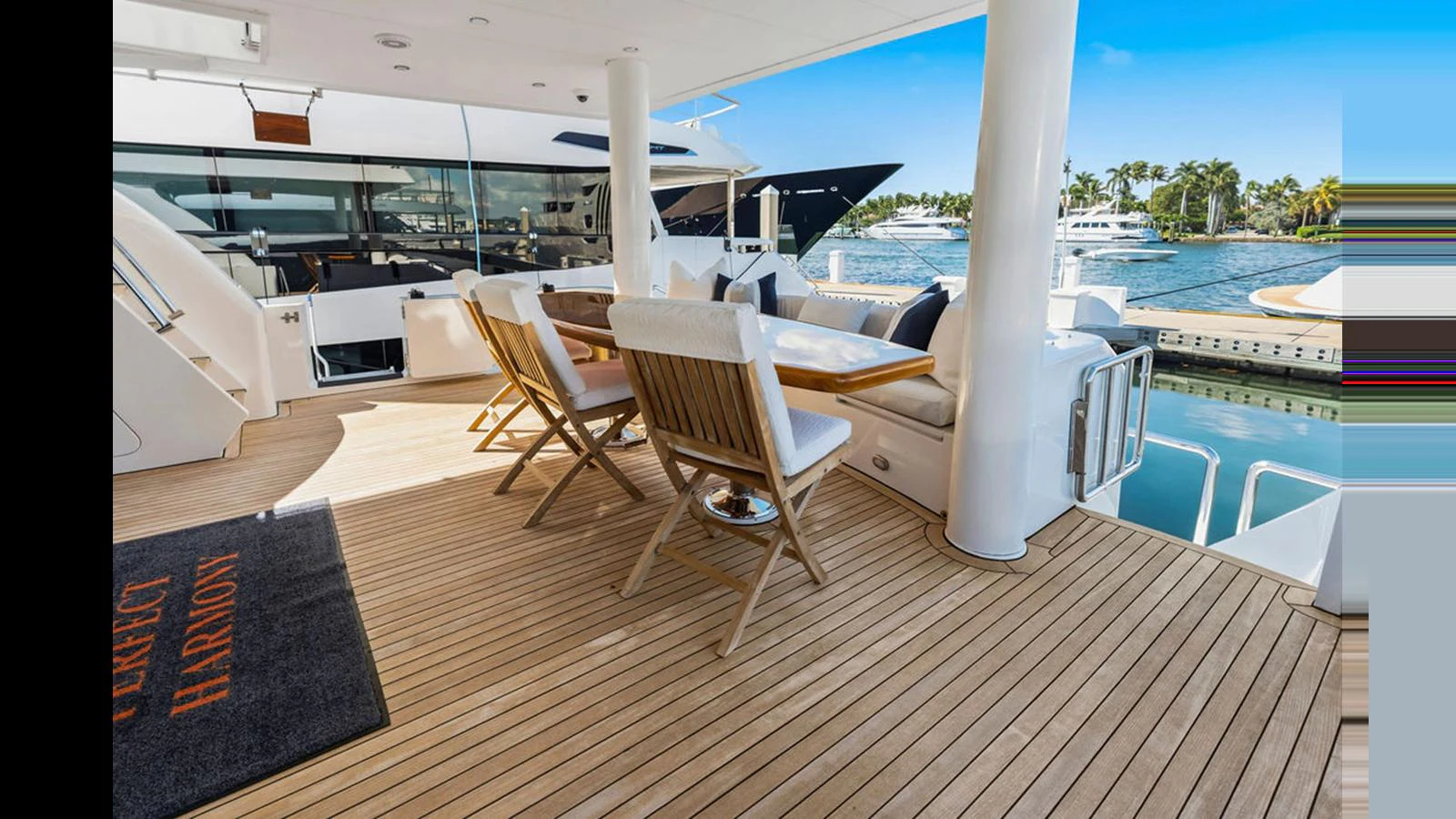 The aft deck features a stylish outdoor dining area with a beautiful view of the marina. aboard PERFECT HARMONY Yacht for Sale