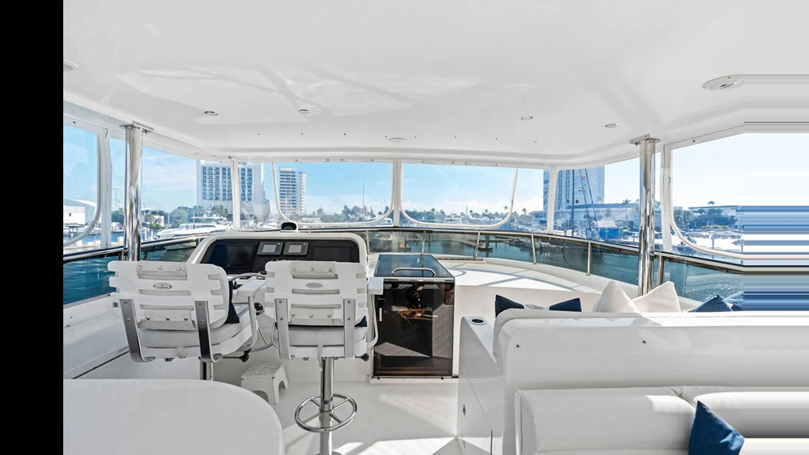 The yacht's helm offers a panoramic view with modern seating and a sleek control panel. aboard PERFECT HARMONY Yacht for Sale