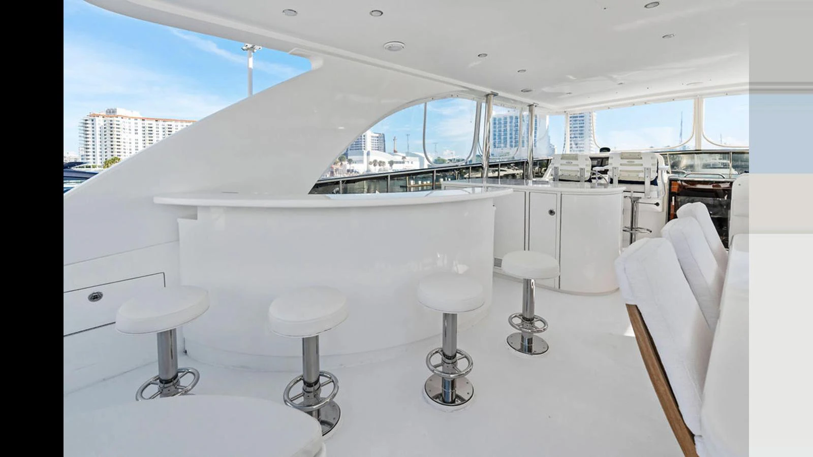 The flybridge features a sleek white bar area with modern seating and panoramic views. aboard PERFECT HARMONY Yacht for Sale