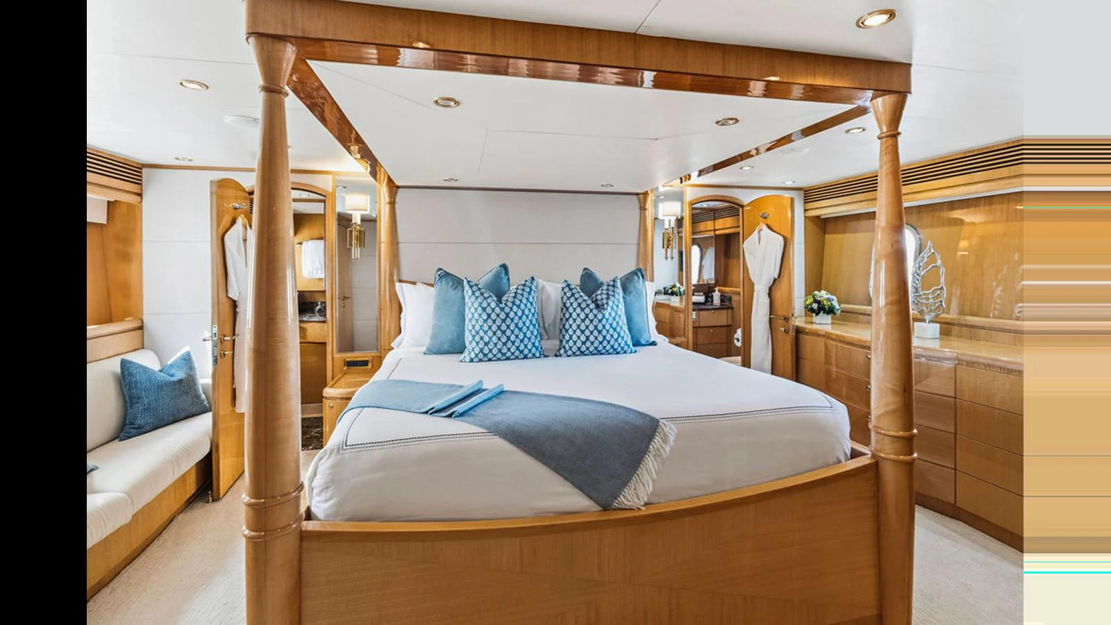 The master stateroom features a luxurious bed with elegant blue accents and ample natural light. aboard PERFECT HARMONY Yacht for Sale
