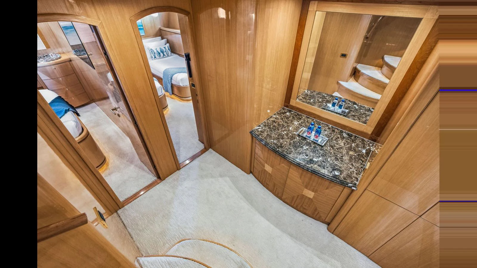 The yacht's interior features a well-appointed hallway with access to multiple staterooms and a marble-topped vanity. aboard PERFECT HARMONY Yacht for Sale