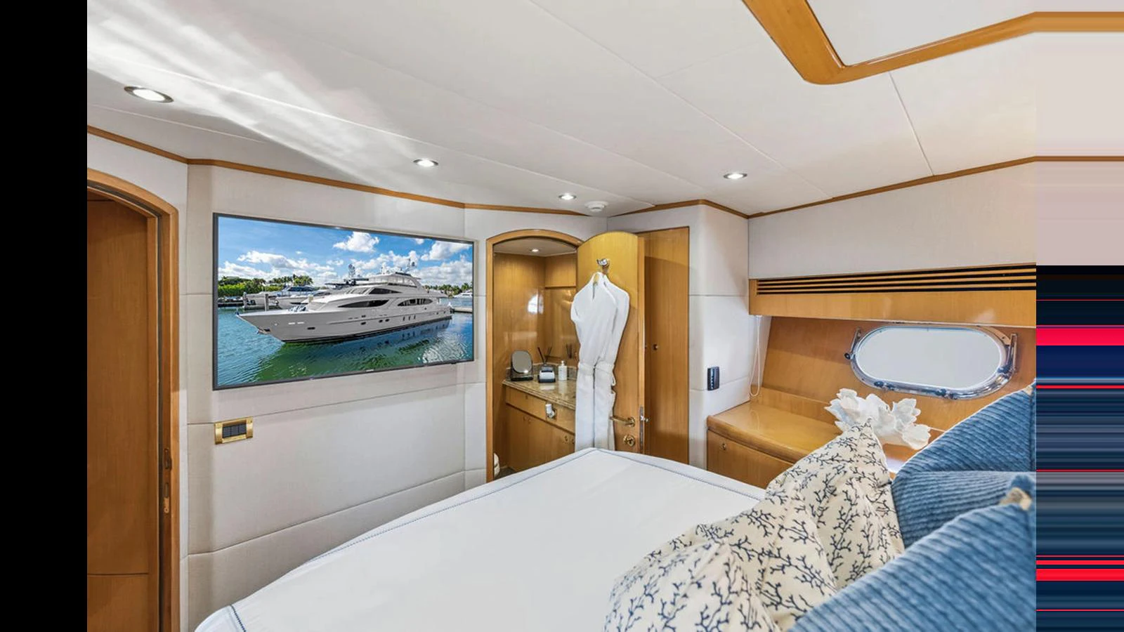 A luxurious stateroom featuring a large bed, ample storage, and a flat-screen TV. aboard PERFECT HARMONY Yacht for Sale