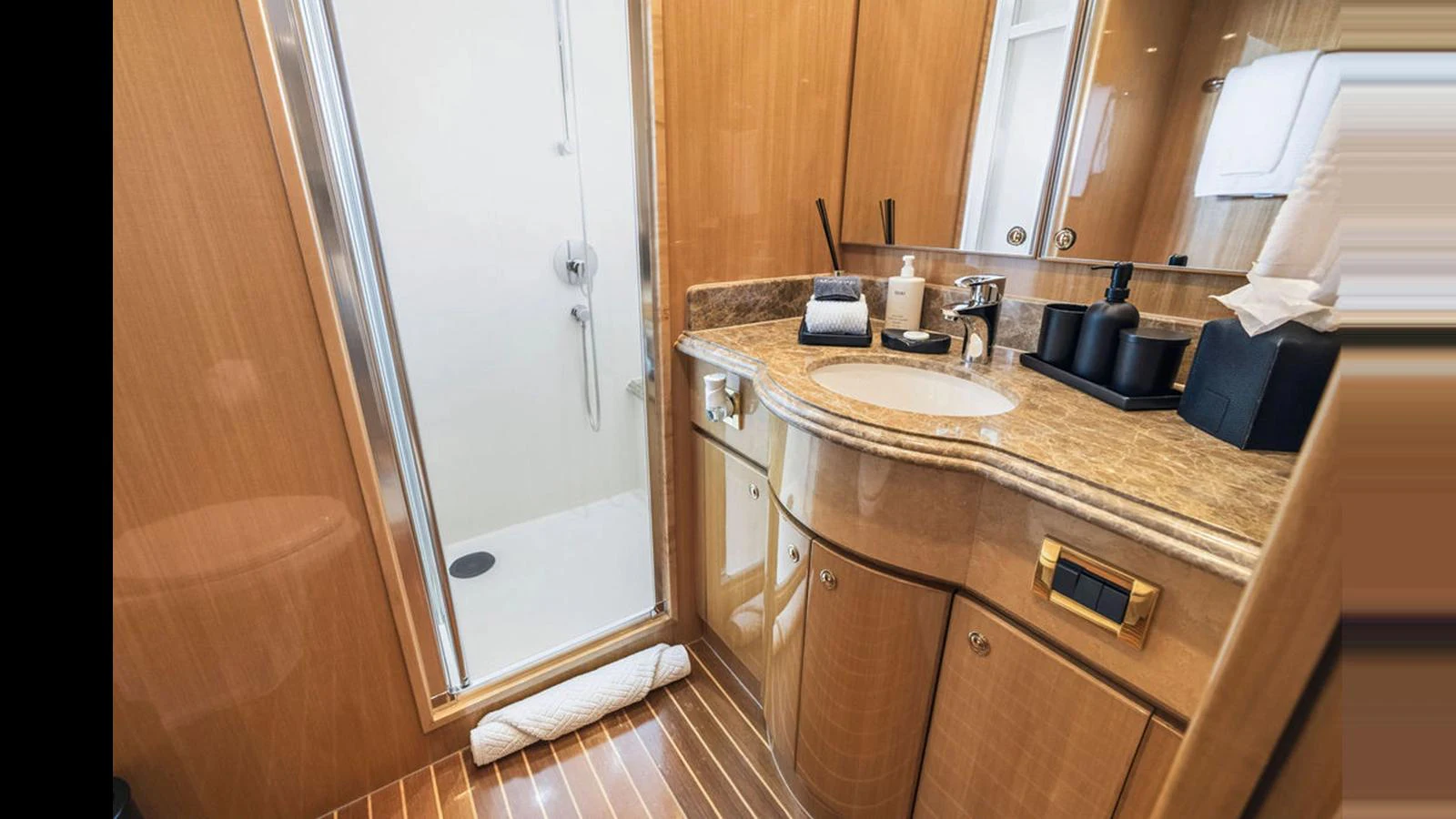 The yacht's bathroom features elegant wood paneling and a sleek, modern shower. aboard PERFECT HARMONY Yacht for Sale