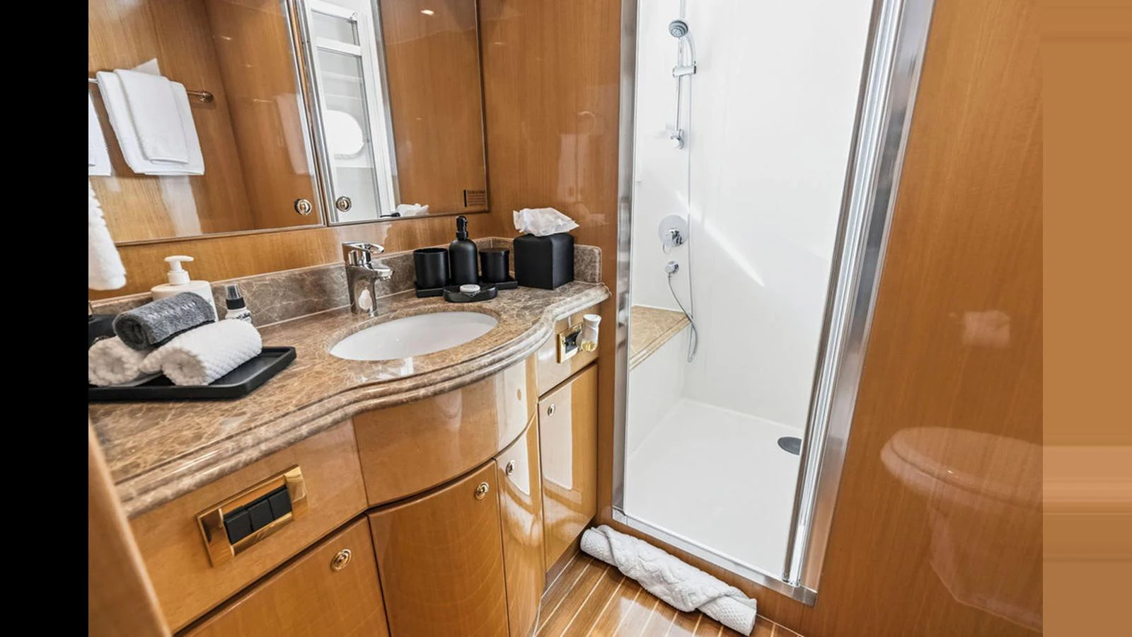 The yacht's bathroom features a sleek design with a spacious shower and elegant wooden cabinetry. aboard PERFECT HARMONY Yacht for Sale