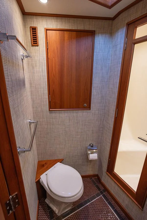 The yacht's head features elegant wood accents and modern fixtures. aboard HT HOOK Yacht for Sale