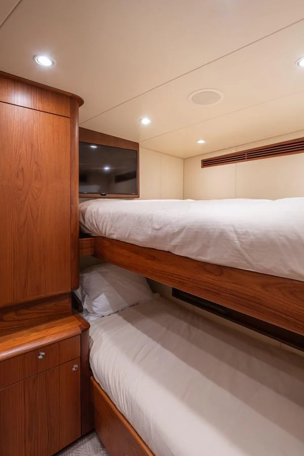 A cozy bunk cabin featuring warm wood finishes and soft lighting. aboard HT HOOK Yacht for Sale