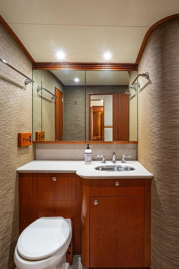A well-appointed yacht bathroom featuring modern fixtures and elegant wood cabinetry. aboard HT HOOK Yacht for Sale