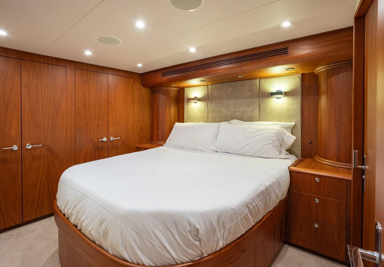 A cozy stateroom with a large bed and warm wooden finishes. aboard HT HOOK Yacht for Sale