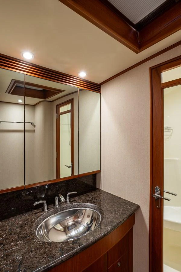 The yacht's bathroom features elegant wood finishes and a sleek countertop. aboard HT HOOK Yacht for Sale