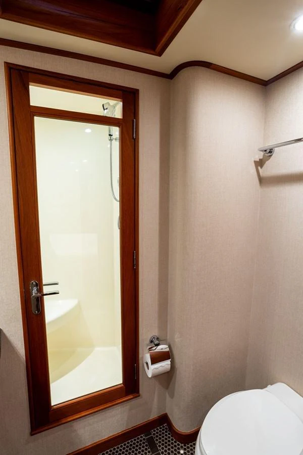A well-appointed yacht bathroom featuring a shower and toilet. aboard HT HOOK Yacht for Sale