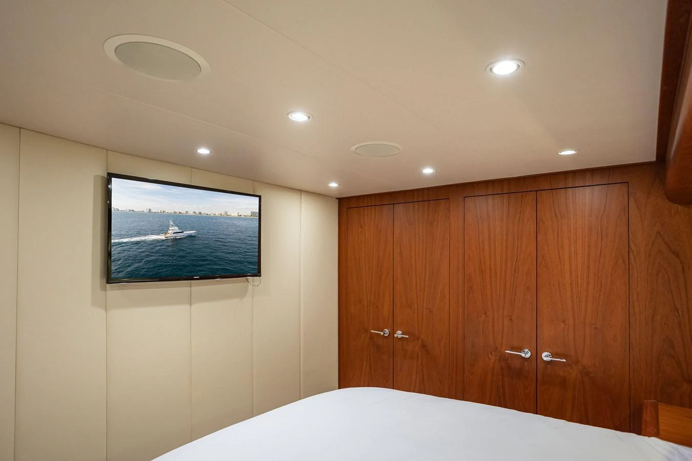 The stateroom features a cozy ambiance with wood paneling and a mounted TV. aboard HT HOOK Yacht for Sale