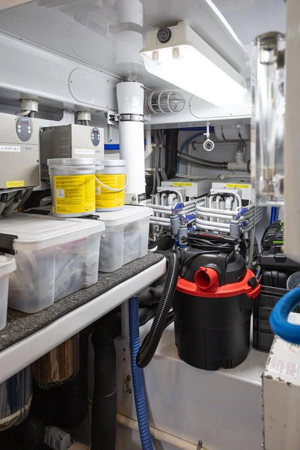 The image showcases a well-organized engine room with various equipment and storage containers. aboard HT HOOK Yacht for Sale