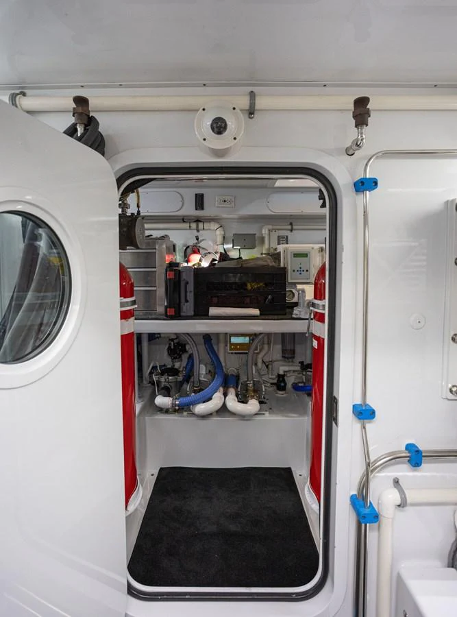 The image shows a technical room on the yacht, featuring various equipment and piping. aboard HT HOOK Yacht for Sale