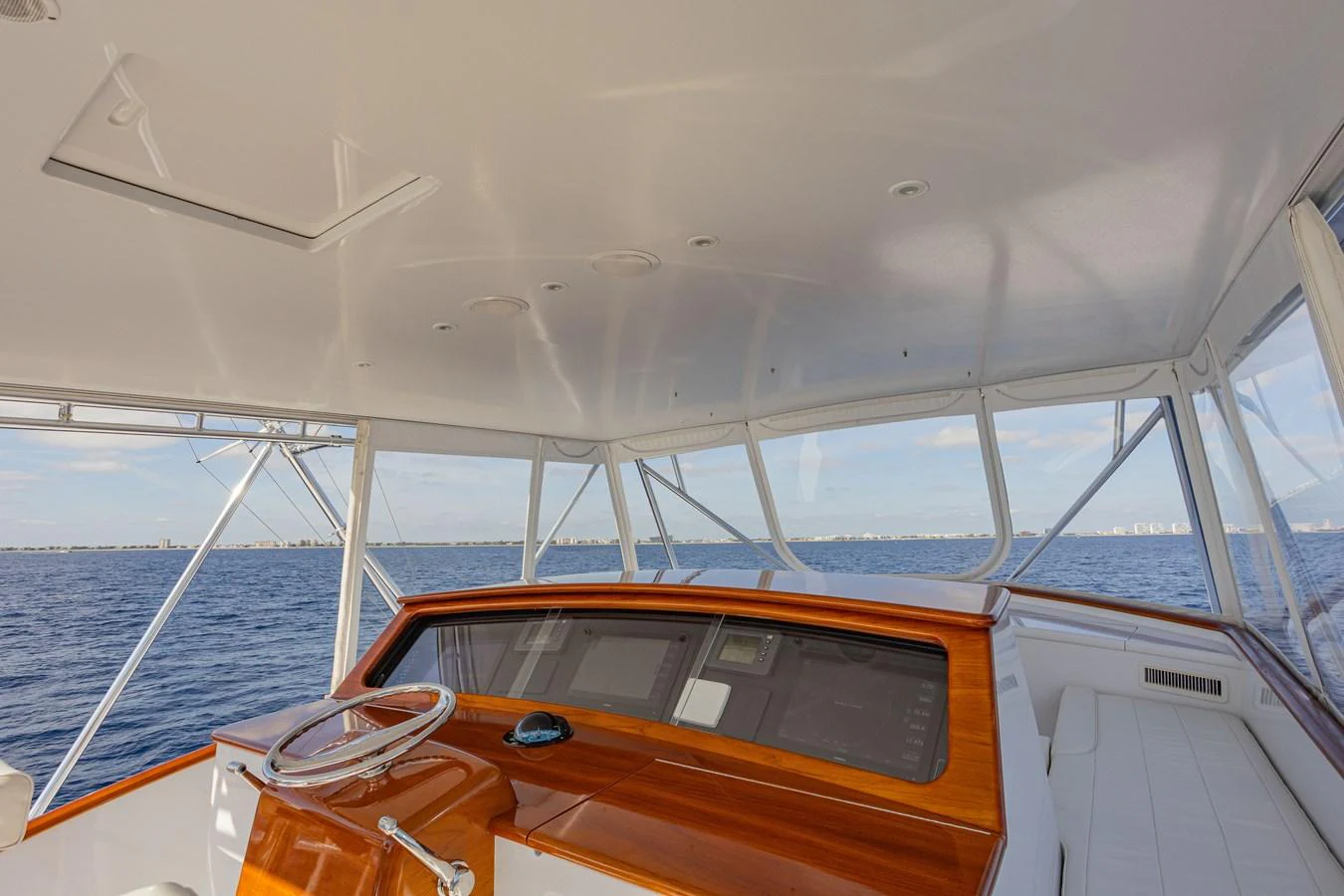 The helm of the yacht offers a panoramic view of the sea with sleek wooden finishes and modern instrumentation. aboard HT HOOK Yacht for Sale