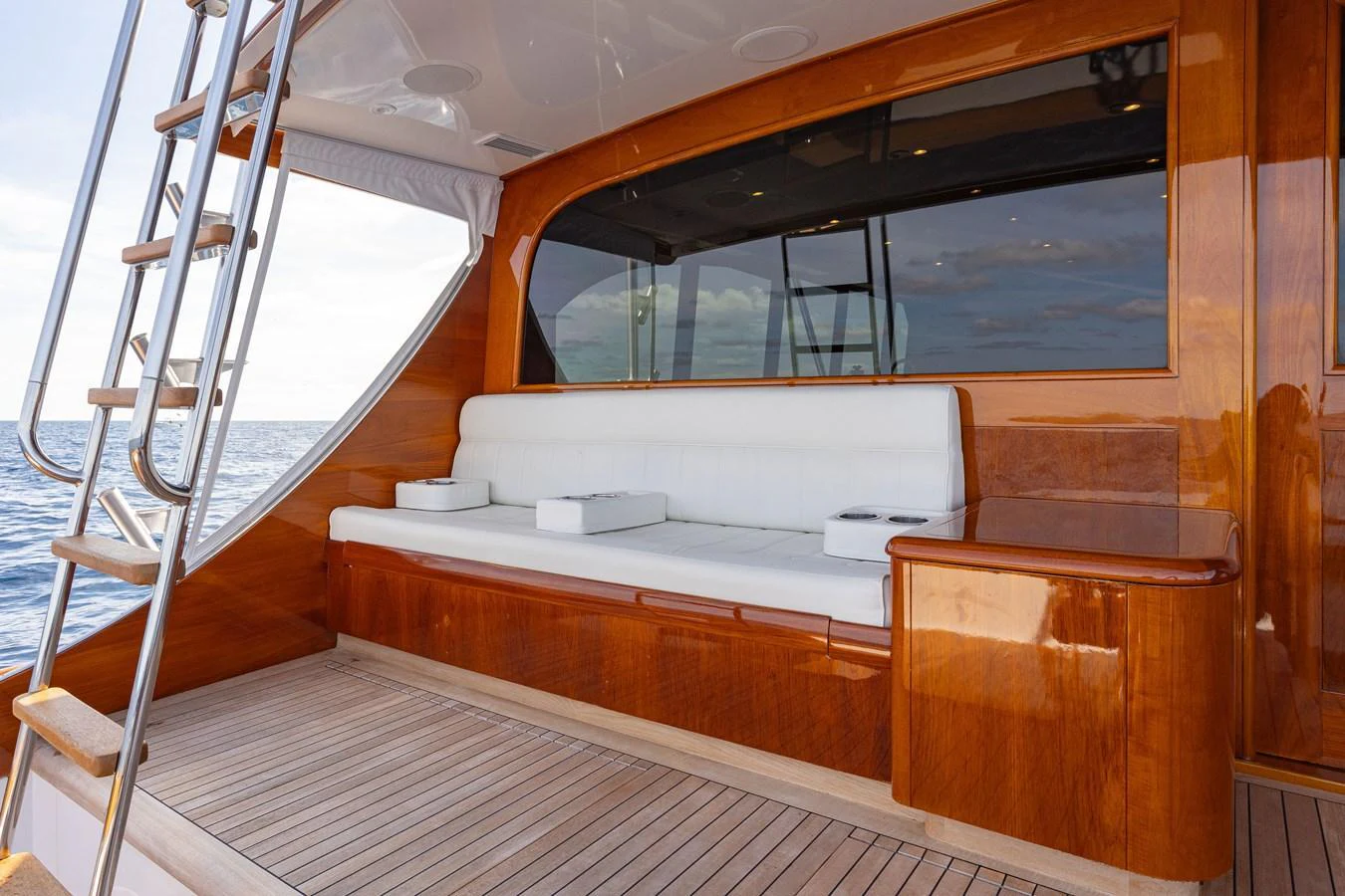 The aft deck features a comfortable seating area with a polished wooden finish and ocean views. aboard HT HOOK Yacht for Sale