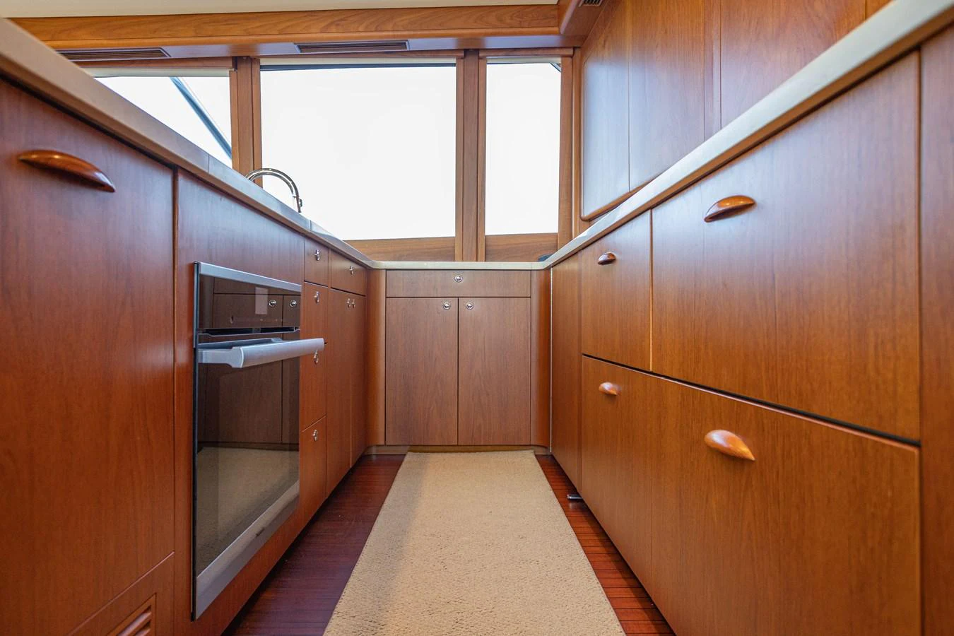 The yacht's galley features warm wood cabinetry and modern appliances. aboard HT HOOK Yacht for Sale
