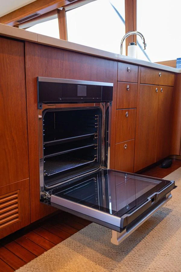 The galley features a modern oven integrated into elegant wooden cabinetry. aboard HT HOOK Yacht for Sale
