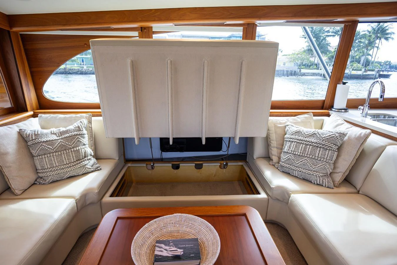 The cozy interior seating area features plush cushions and a hidden TV for a luxurious experience. aboard HT HOOK Yacht for Sale