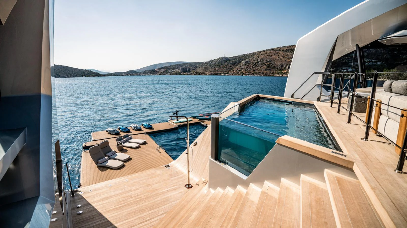 a deck with a view of the ocean and mountains aboard THIS IS IT I Yacht for Sale