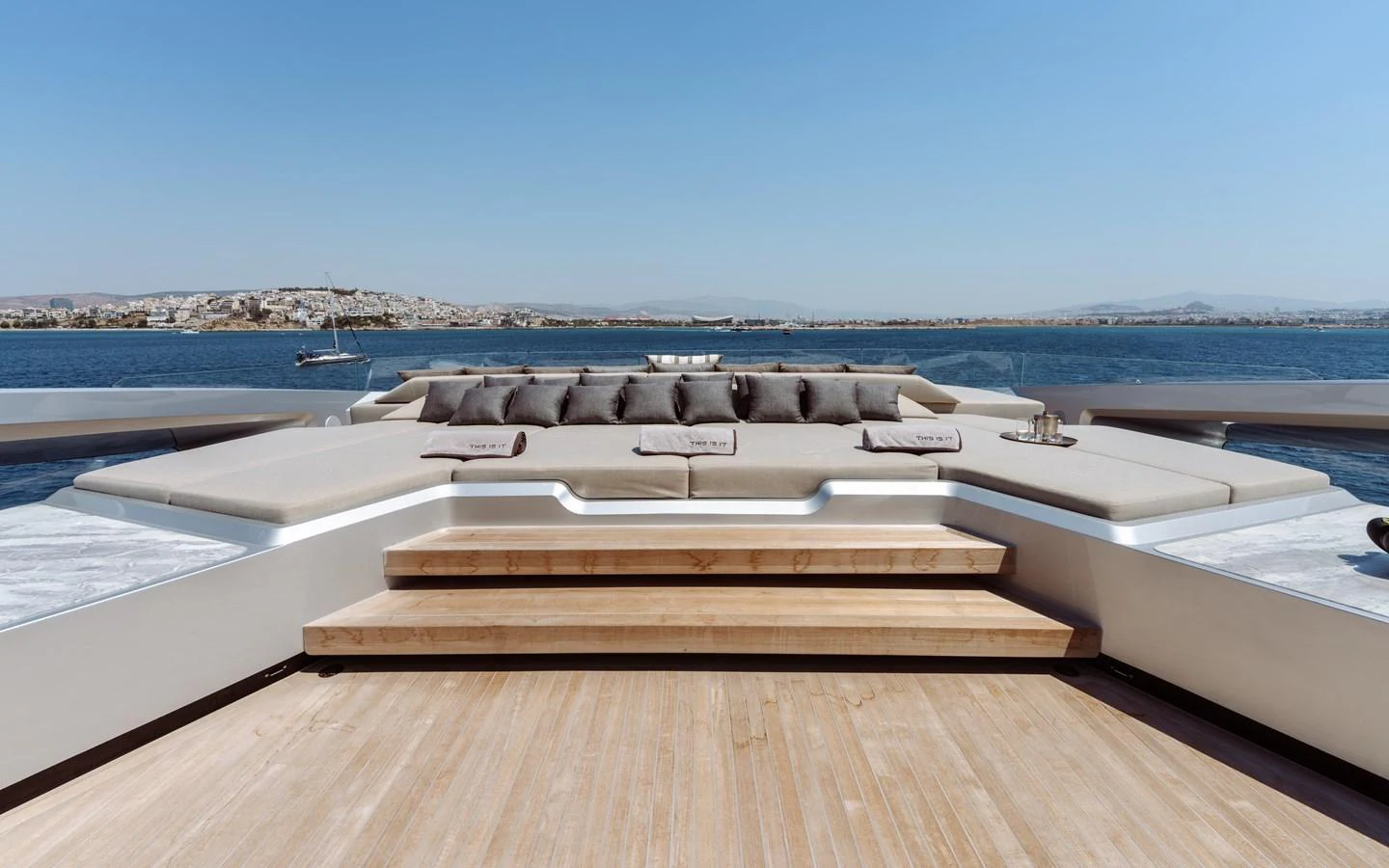 a deck with a large pool of water and a boat in the background aboard THIS IS IT I Yacht for Sale