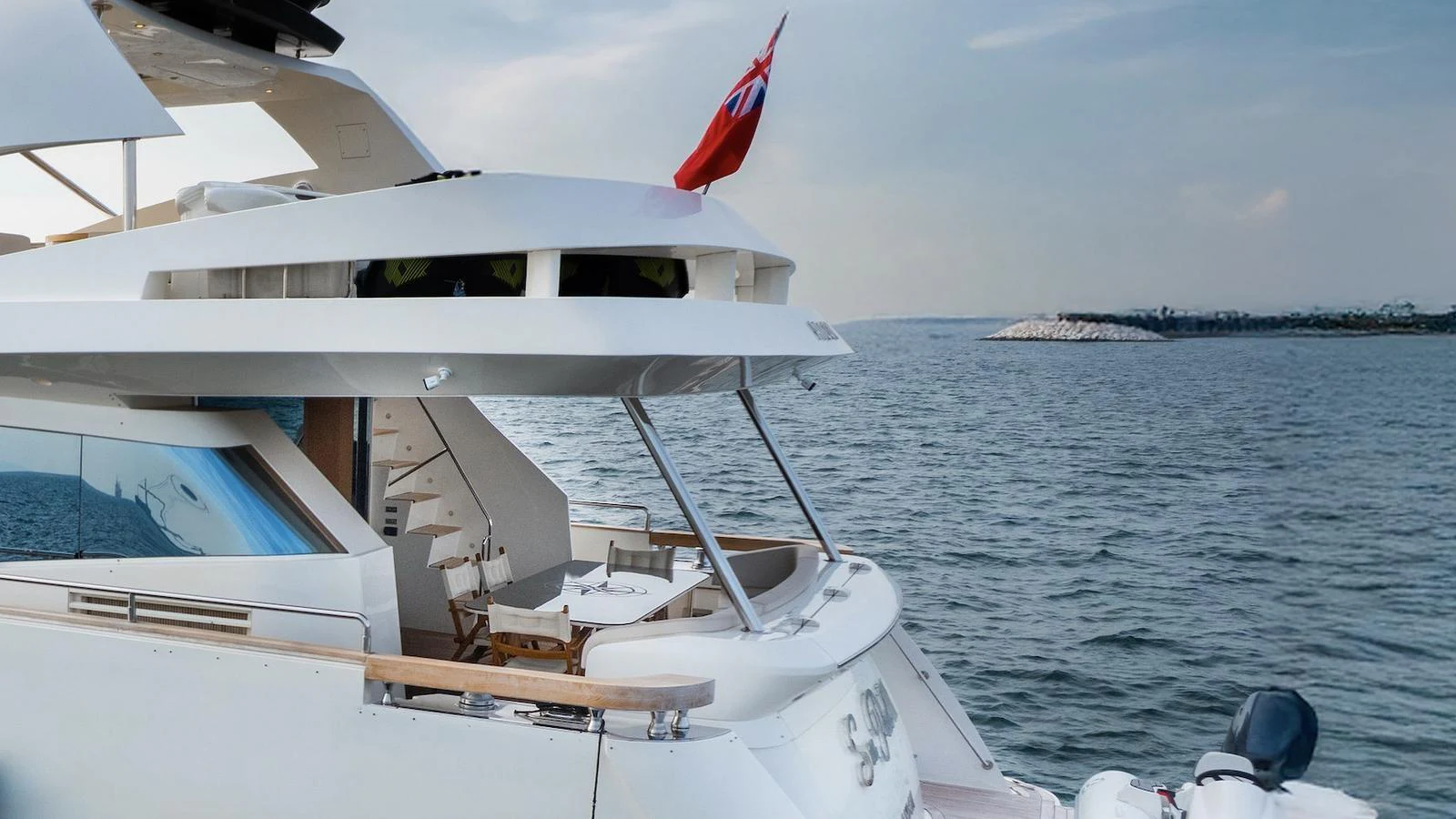 The yacht's aft deck features a cozy dining area with a scenic ocean backdrop. aboard SEA PEARL 2 Yacht for Sale