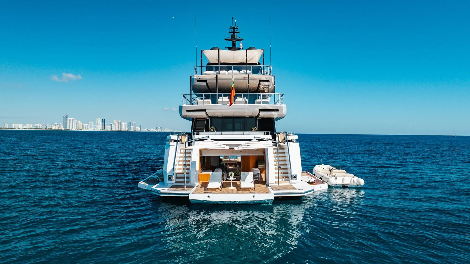 A luxurious yacht anchored on the water with a view of the city skyline in the background. aboard NEVERLAND II Yacht for Sale