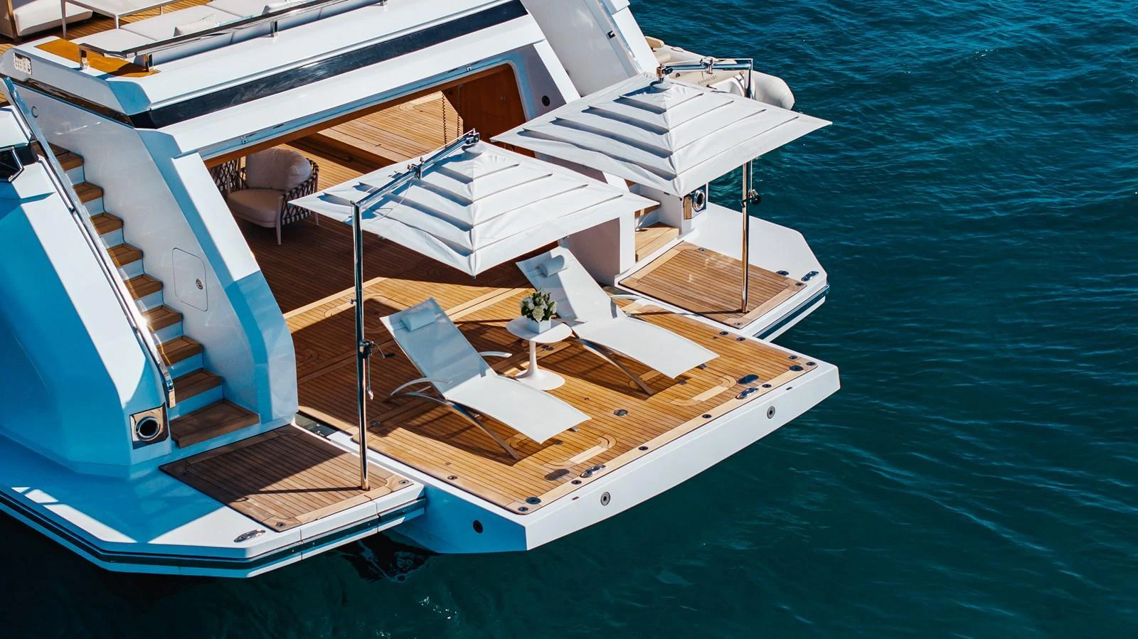 The yacht's beach club features a spacious deck with sun loungers and umbrellas, perfect for relaxation by the water. aboard NEVERLAND II Yacht for Sale