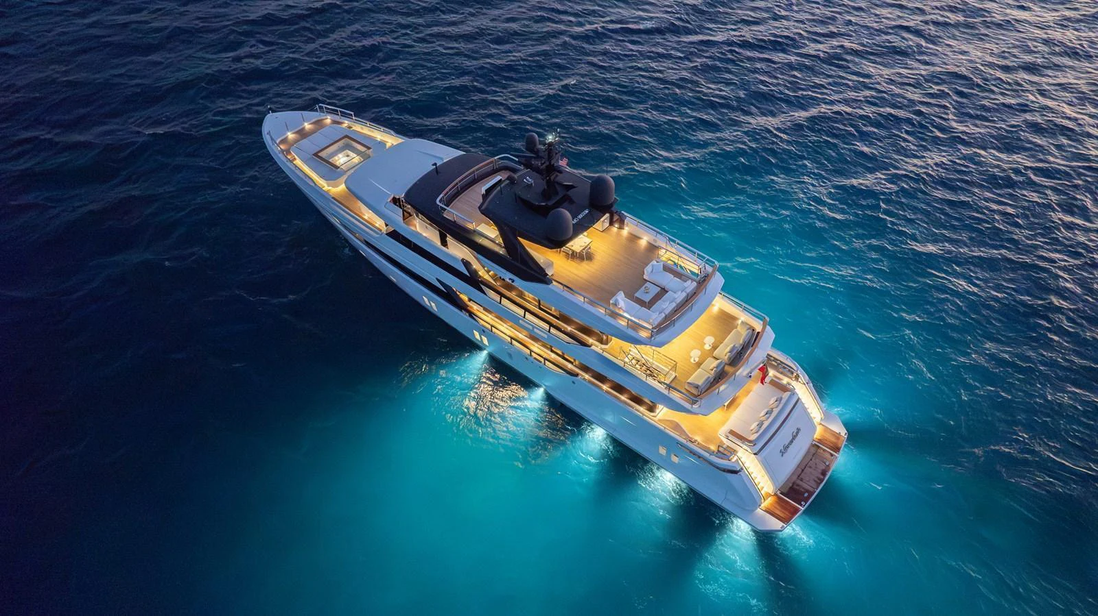 A stunning yacht illuminated at night, cruising through serene waters. aboard NEVERLAND II Yacht for Sale