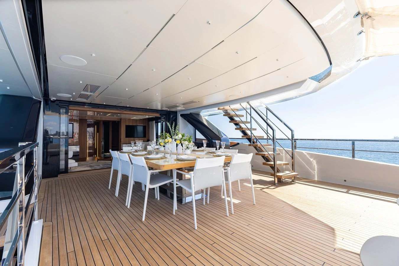 The aft deck features an elegant dining area with a stunning ocean view. aboard NEVERLAND II Yacht for Sale