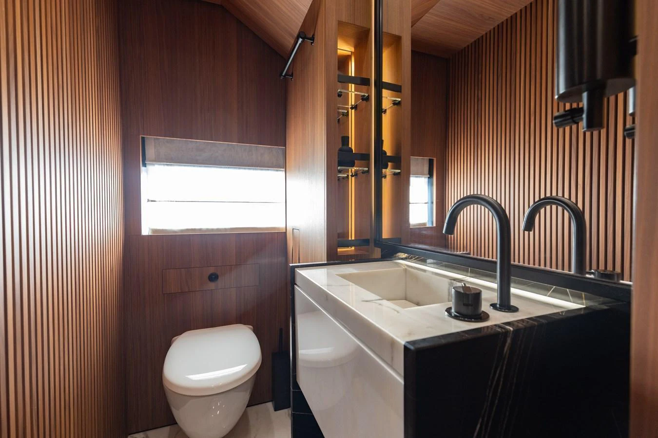 The yacht's bathroom features elegant wood paneling and modern fixtures. aboard NEVERLAND II Yacht for Sale