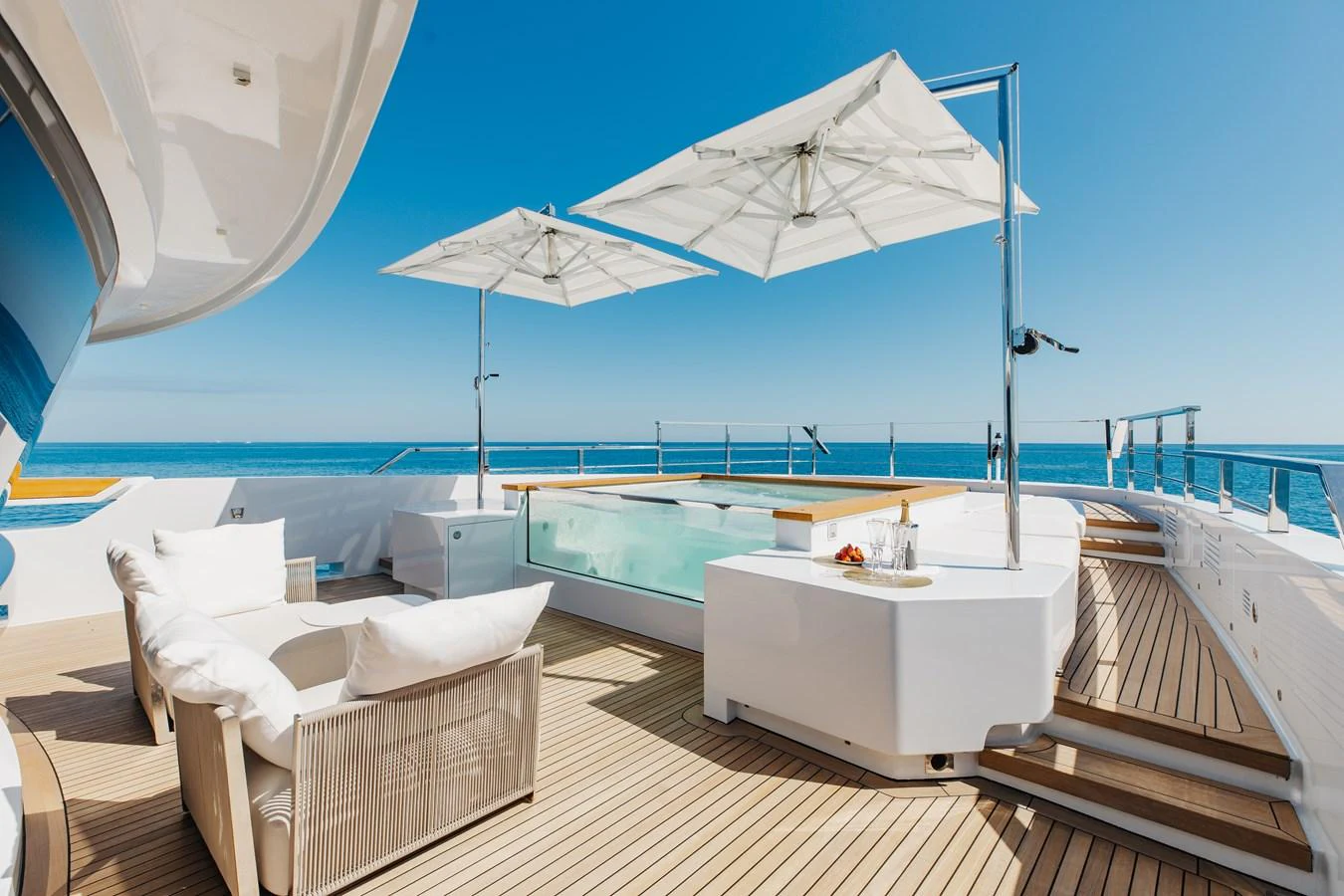 The sundeck features luxurious seating, a jacuzzi, and sun umbrellas, perfect for relaxation and enjoying the ocean views. aboard NEVERLAND II Yacht for Sale