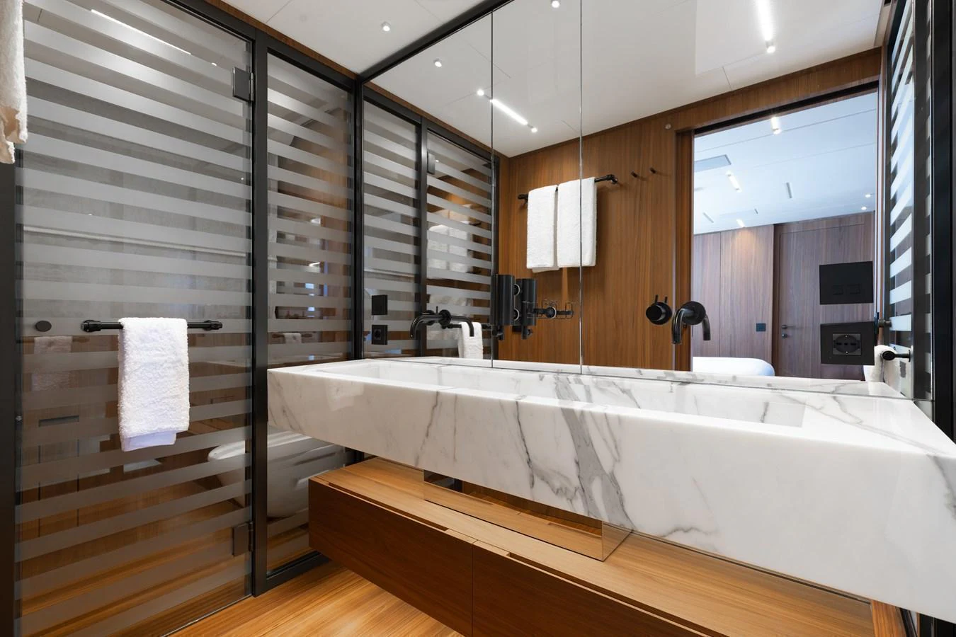 The yacht's bathroom features a sleek, modern design with a marble countertop and wooden accents. aboard NEVERLAND II Yacht for Sale