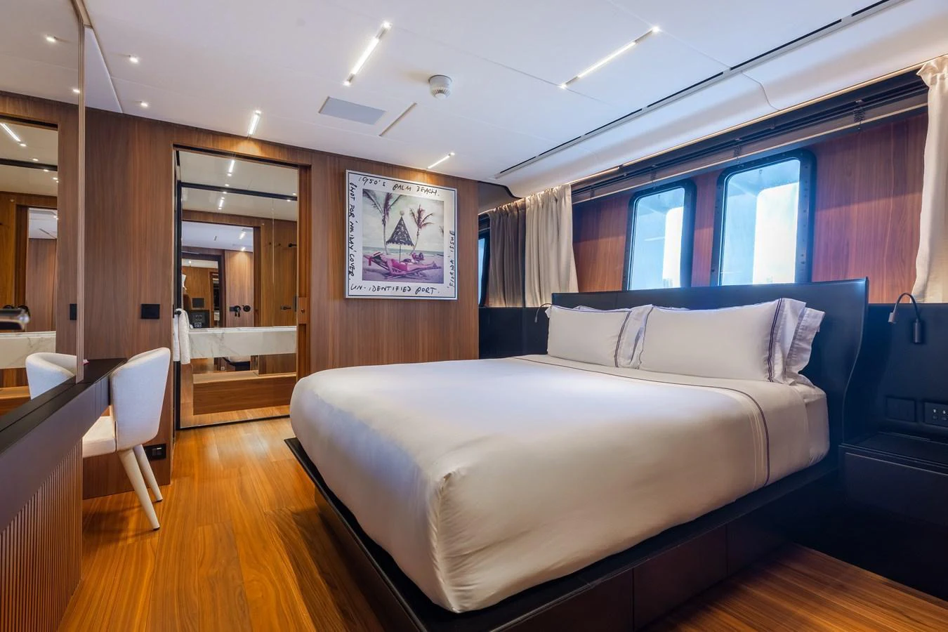 The master stateroom features a luxurious bed, elegant wood paneling, and large windows for natural light. aboard NEVERLAND II Yacht for Sale