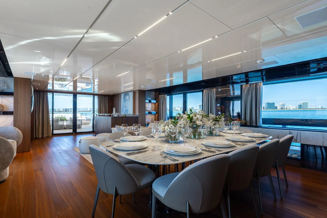The yacht's dining area features a beautifully set table with elegant place settings and a stunning view through large windows. aboard NEVERLAND II Yacht for Sale