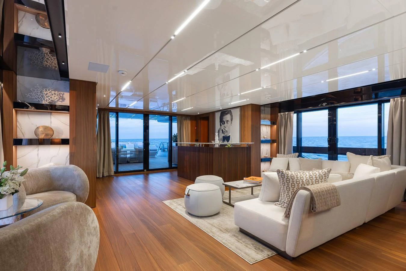 The yacht's salon features elegant seating and a stunning ocean view through large windows. aboard NEVERLAND II Yacht for Sale