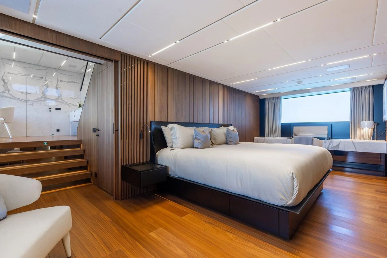 The master stateroom features a spacious bed, elegant wood paneling, and modern lighting. aboard NEVERLAND II Yacht for Sale