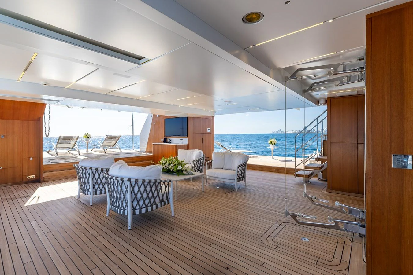 The aft deck features a spacious seating area with elegant furniture and a stunning ocean view. aboard NEVERLAND II Yacht for Sale