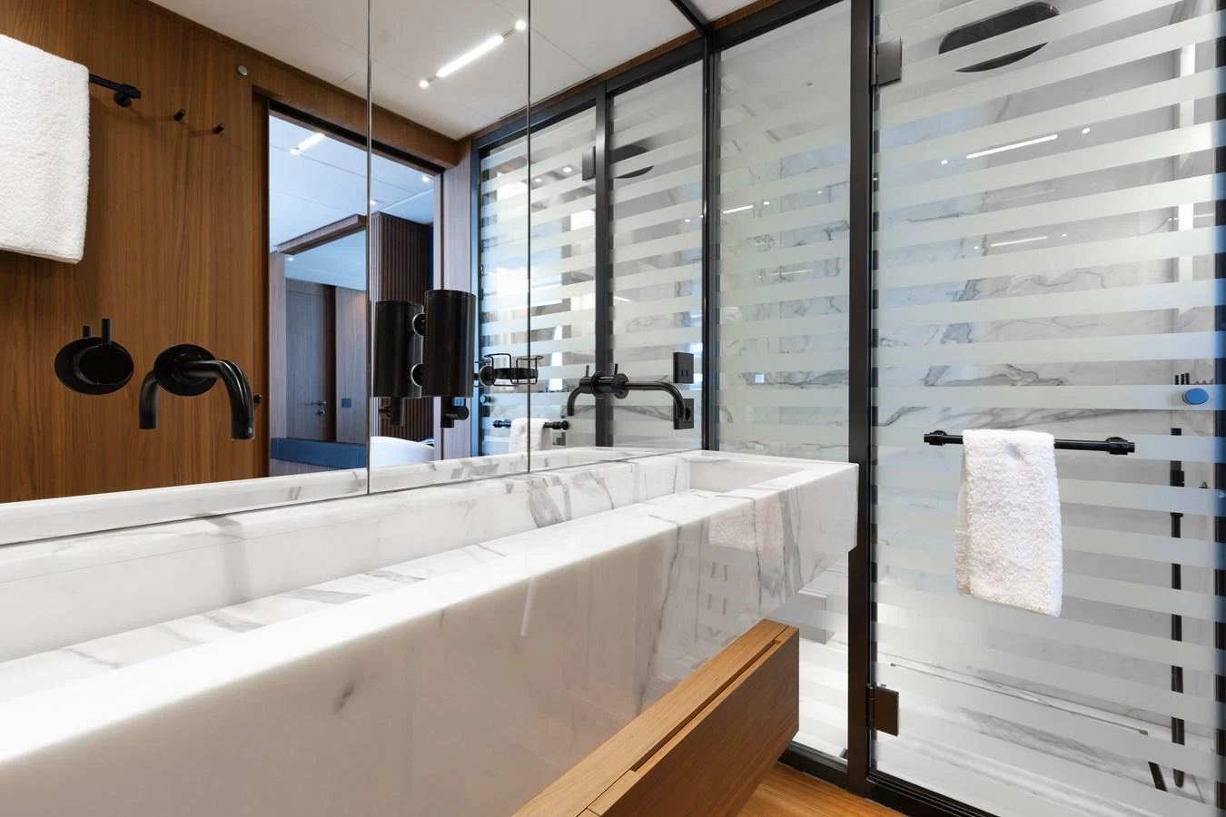 The yacht's bathroom features a sleek, modern design with a marble sink and wooden accents. aboard NEVERLAND II Yacht for Sale