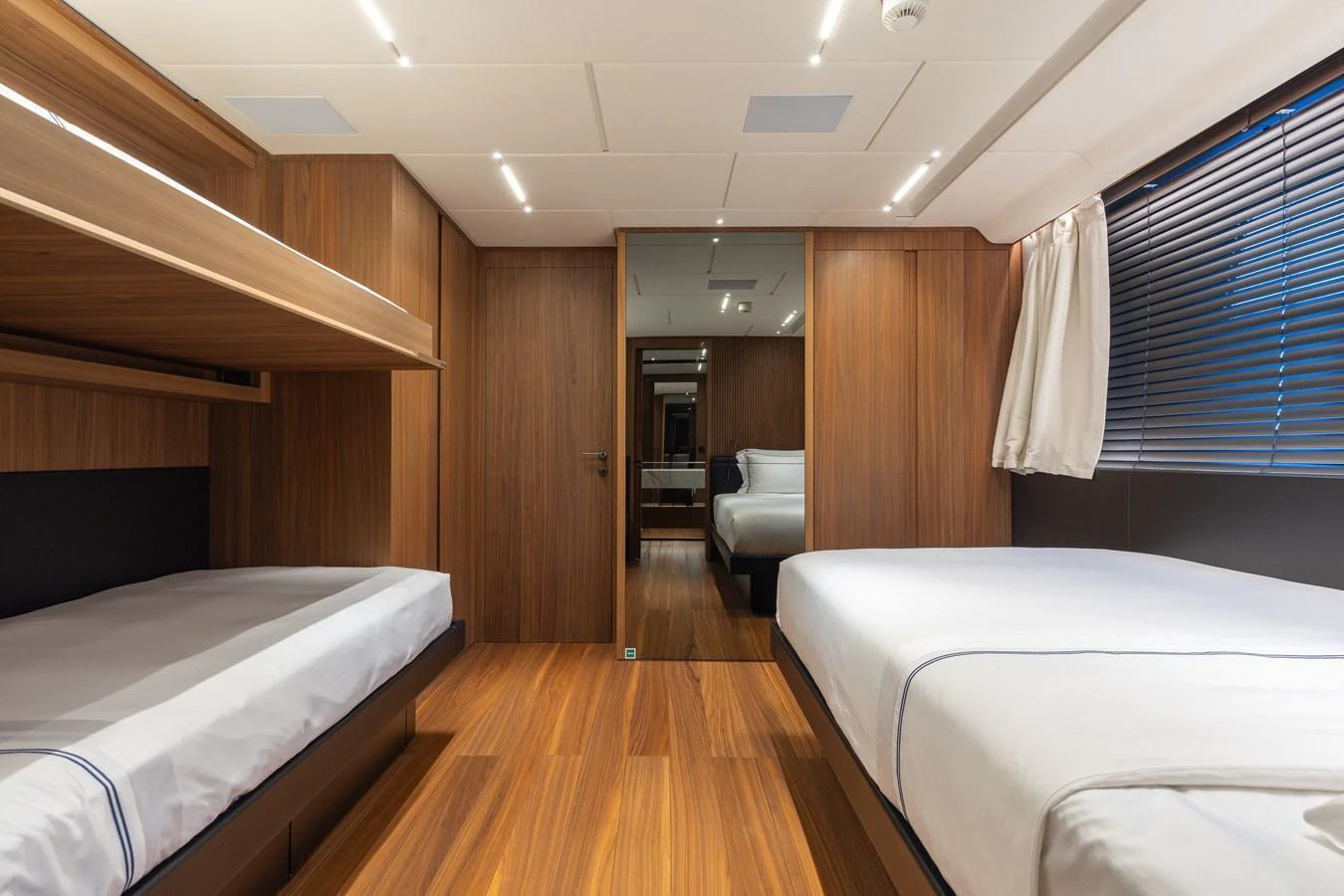 This guest stateroom features twin beds and warm wood paneling, creating a cozy and inviting atmosphere. aboard NEVERLAND II Yacht for Sale