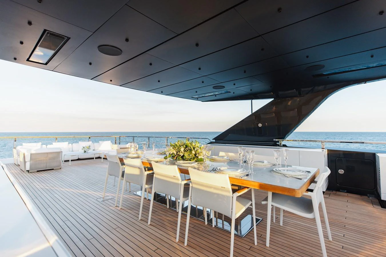 The aft deck features an elegant dining area with a large table and comfortable seating, perfect for alfresco dining with ocean views. aboard NEVERLAND II Yacht for Sale