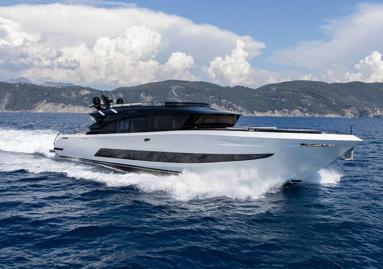 A sleek and modern yacht cruises swiftly through the open water against a backdrop of scenic mountains. aboard 50 SHADES OF PLAY Yacht for Sale